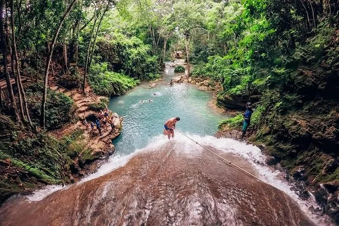 Tourist floating on an inner tube through lush tropical jungle on the White River river tubing excursion in Ocho Rios Jamaica